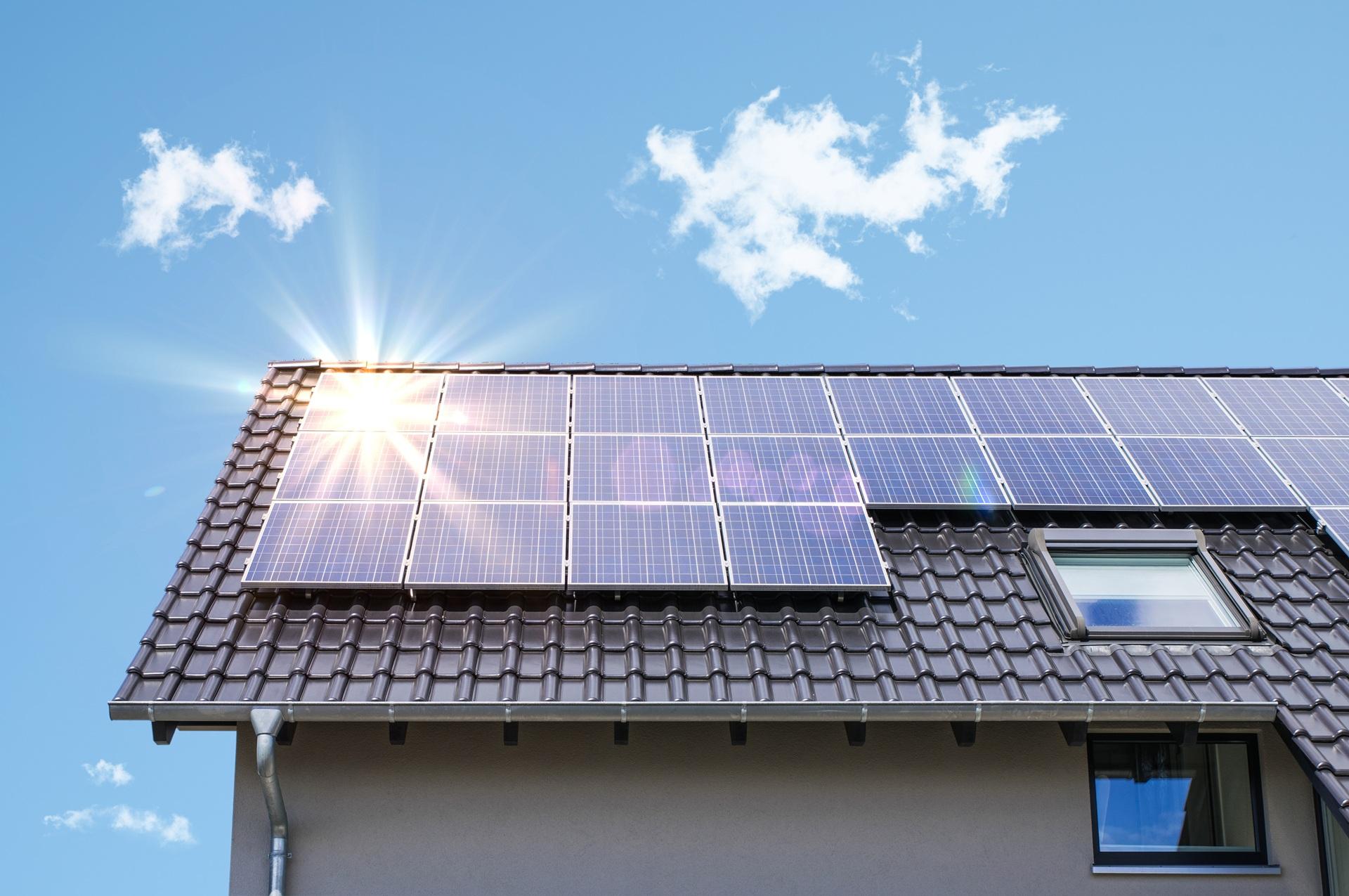 Hausdach mit Solarpaneelen und Sonne | Sonnenschutz Markisen